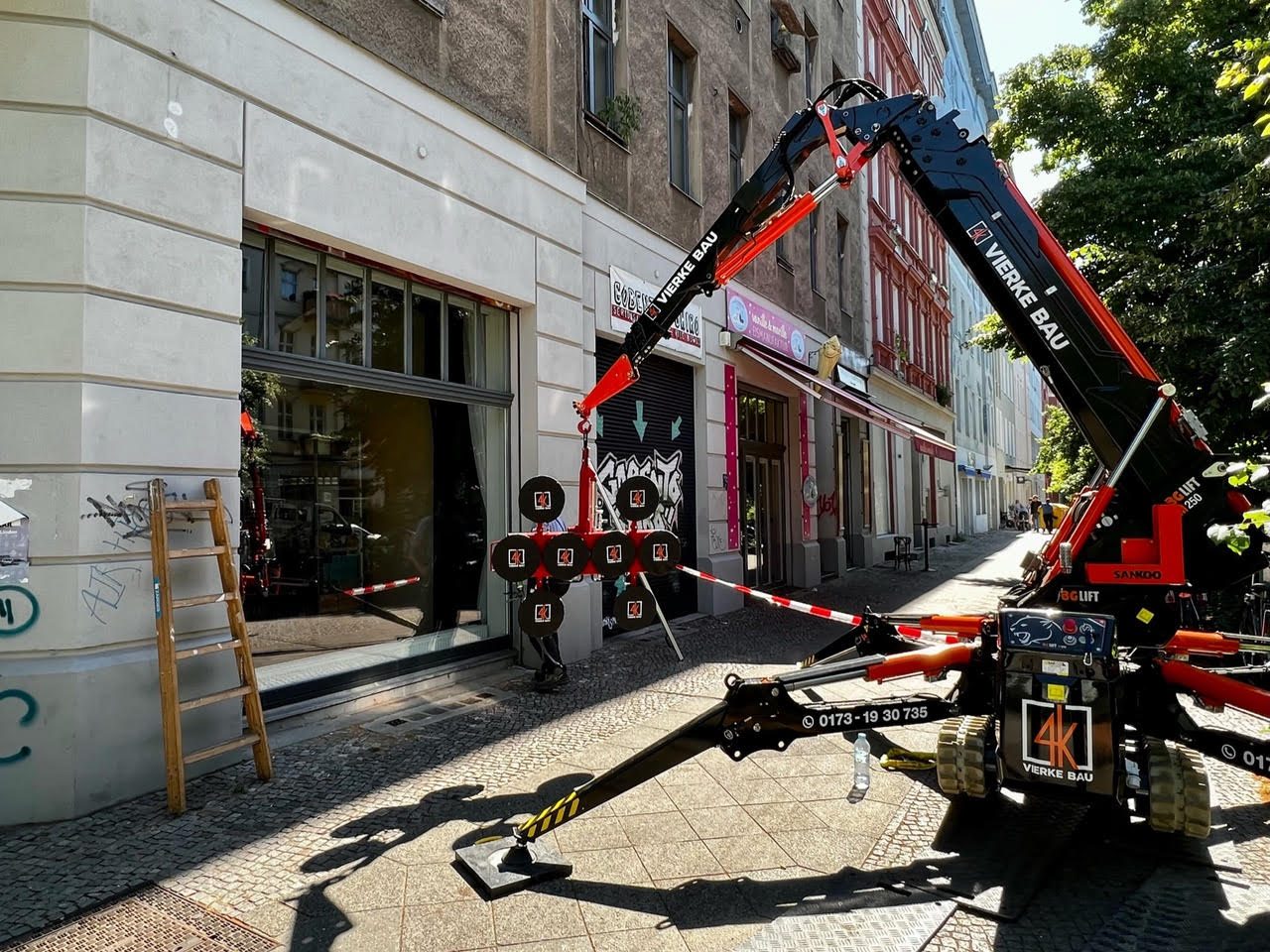 Minikran setzt eine Schaufensterscheibe per Glassauger